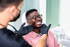 Dentist looking at patient's smile in treatment room