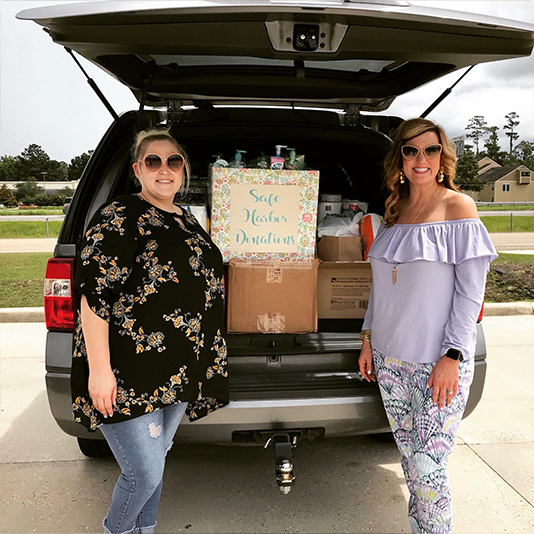 Two Slidell dental team members with car trunk full of donation items