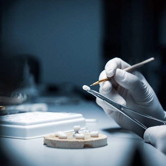 Dentist creating dental crowns with small instruments