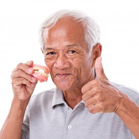 Smiling man with his dentures