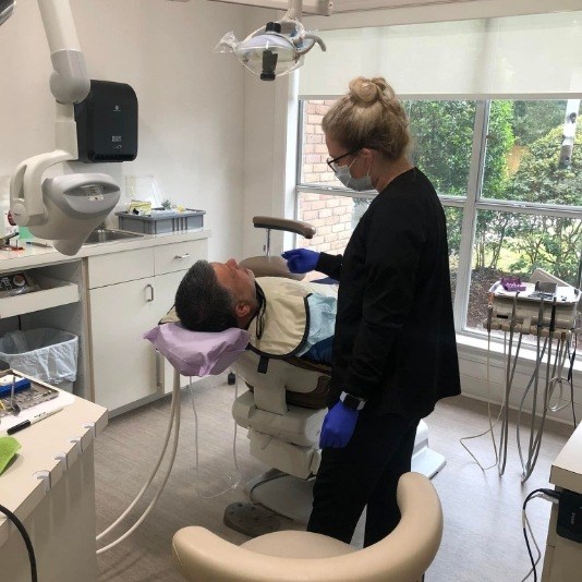 Dental team member talking with a patient in the dental chair