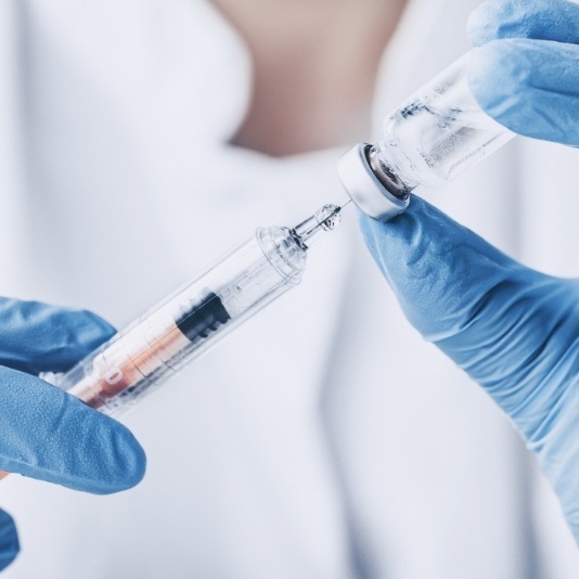 Dentist drawing a syringe