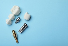 Parts of dental implants lying on a blue surface