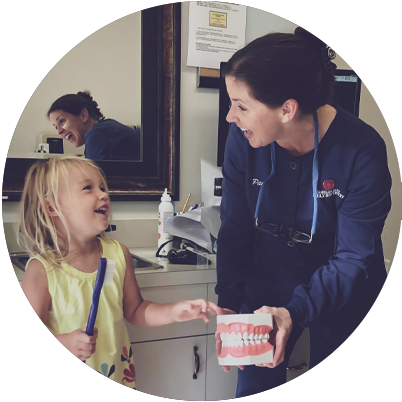 Slidell dental team member laughing with young girl dental patient