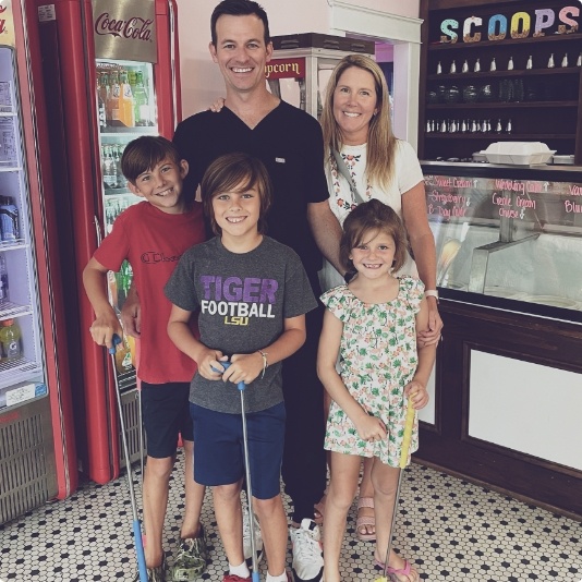 Doctor Steve smiling with his family in an ice cream shop