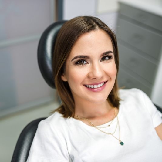Woman in dental chair smiling during preventive dentistry visit in Slidell