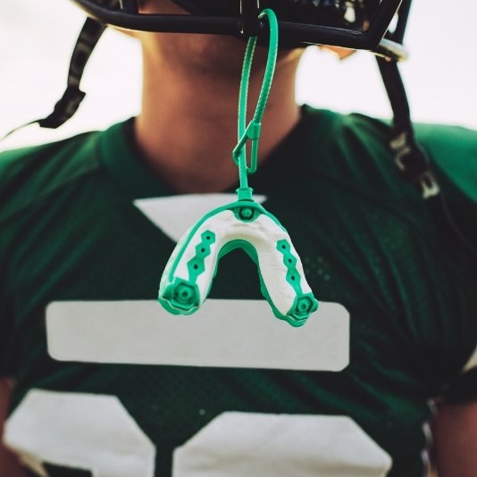 Athletic mouthguard hanging from football helmet