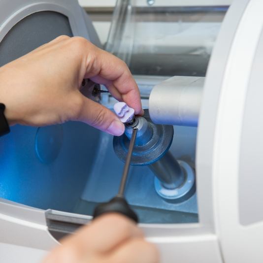 Dentist using a machine to craft a one visit dental crown