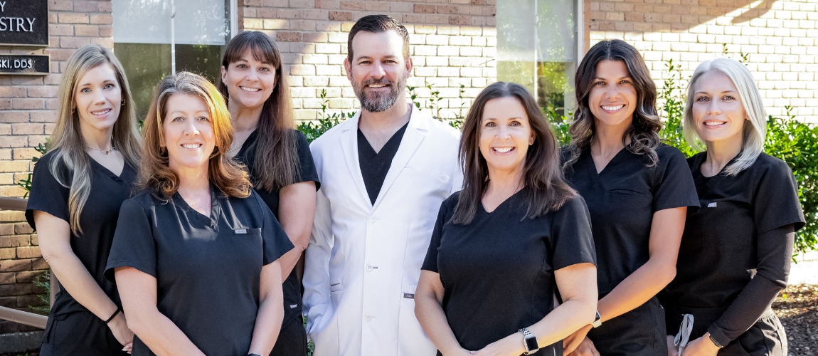 Smiling Slidell dental team member sitting at desk