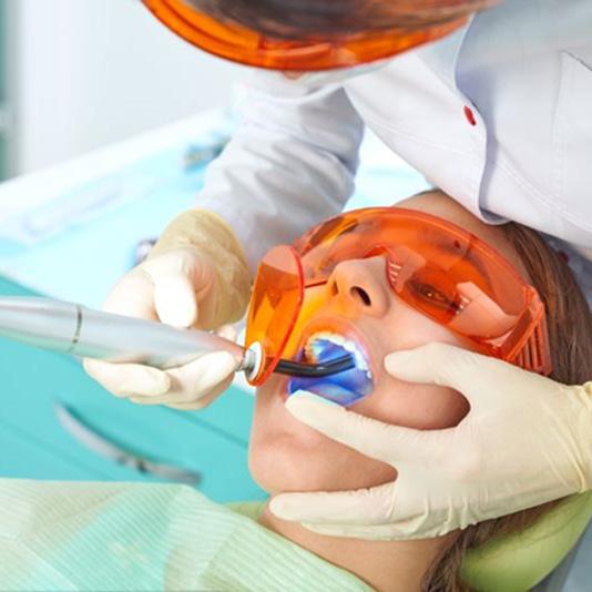 Woman in dental chair getting a tooth colored filling