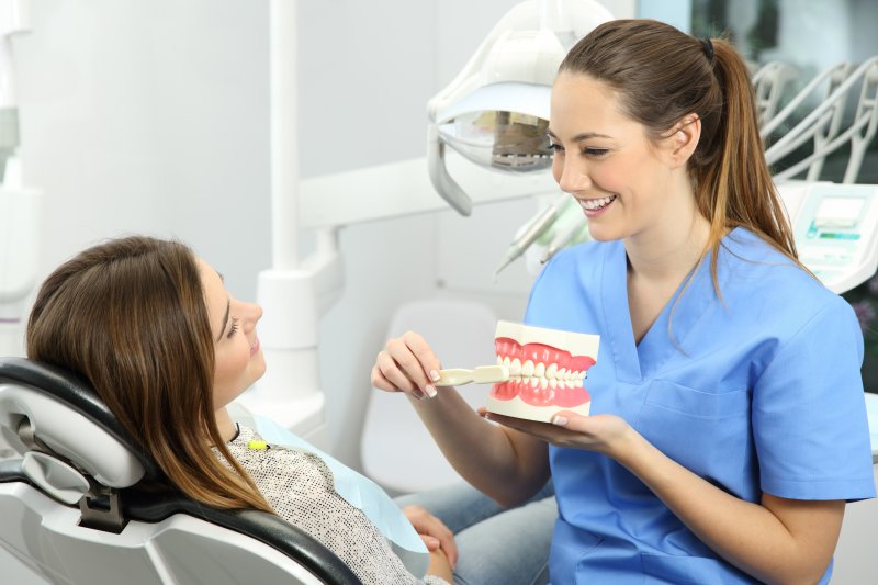 A dental hygienist talking to a patient about her teeth cleaning